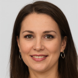 Joyful white adult female with long  brown hair and grey eyes