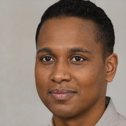 Joyful black young-adult male with short  black hair and brown eyes