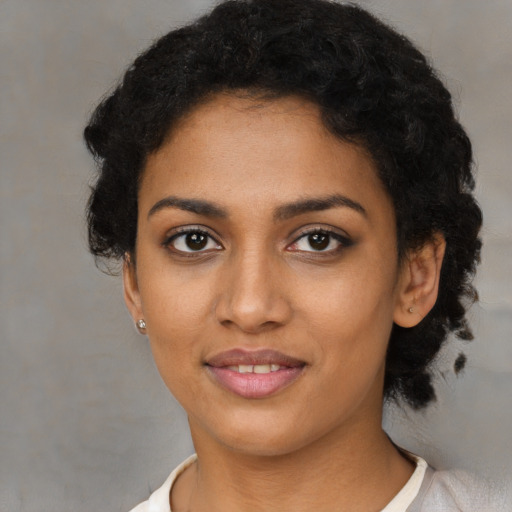 Joyful black young-adult female with short  black hair and brown eyes