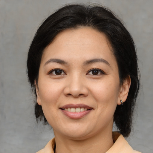 Joyful asian young-adult female with medium  brown hair and brown eyes