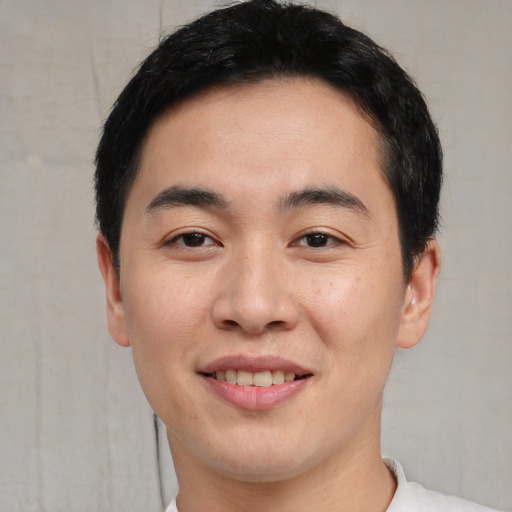 Joyful asian young-adult male with short  black hair and brown eyes