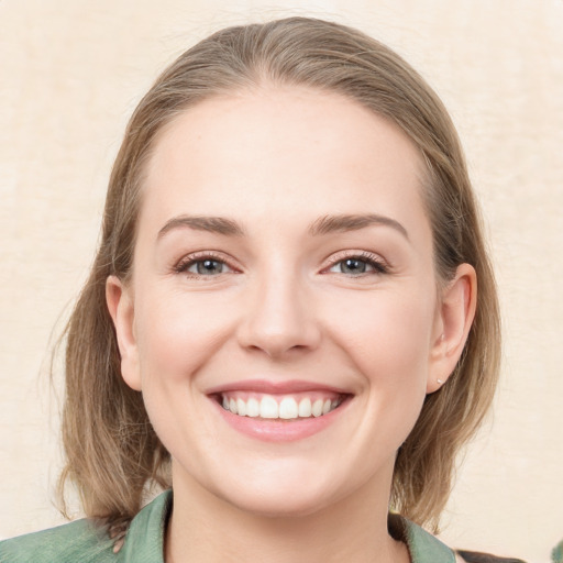 Joyful white young-adult female with medium  brown hair and green eyes