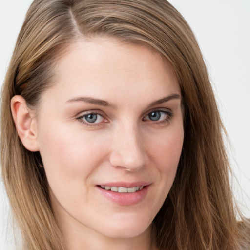 Joyful white young-adult female with long  brown hair and blue eyes