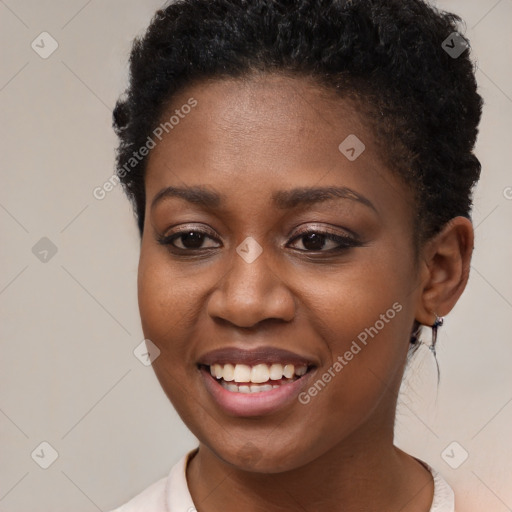 Joyful black young-adult female with short  brown hair and brown eyes