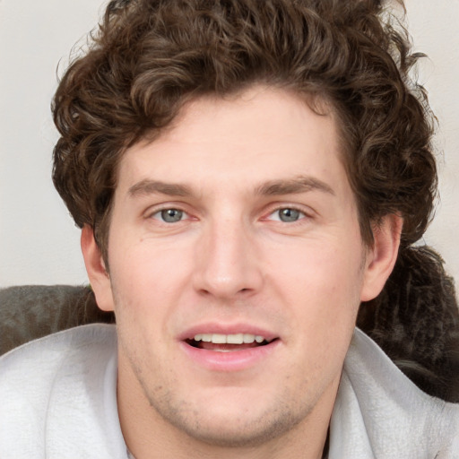 Joyful white young-adult male with short  brown hair and blue eyes