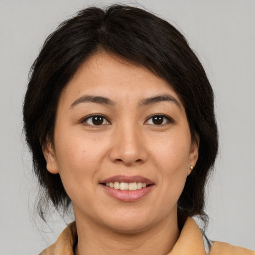 Joyful latino young-adult female with medium  brown hair and brown eyes