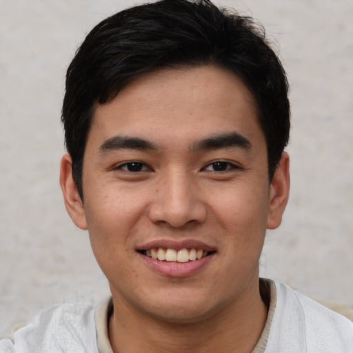 Joyful asian young-adult male with short  black hair and brown eyes