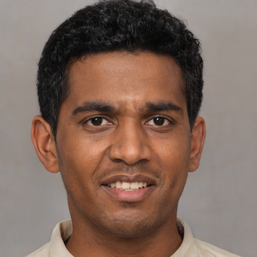 Joyful black young-adult male with short  black hair and brown eyes