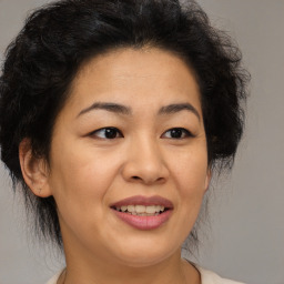 Joyful latino adult female with medium  brown hair and brown eyes