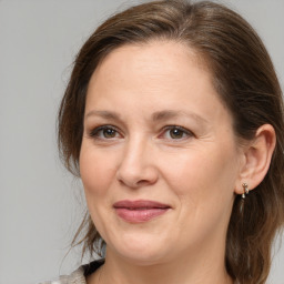 Joyful white adult female with medium  brown hair and grey eyes