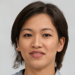 Joyful asian young-adult female with medium  brown hair and brown eyes