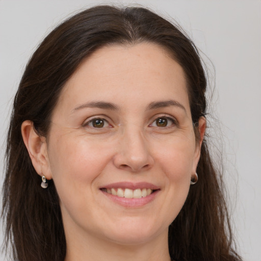 Joyful white young-adult female with long  brown hair and grey eyes