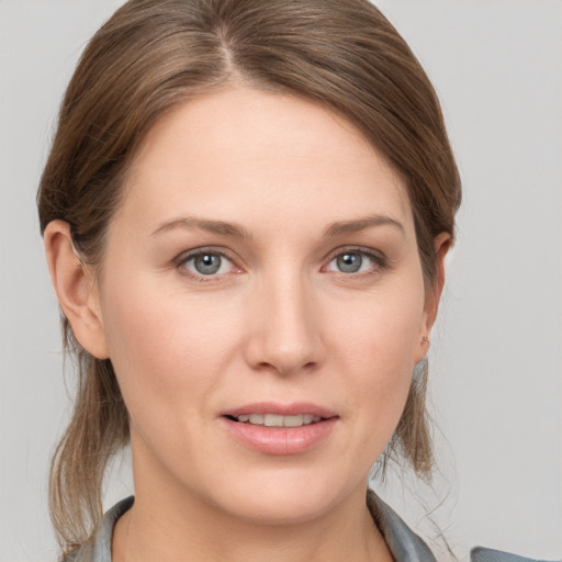 Joyful white young-adult female with medium  brown hair and grey eyes