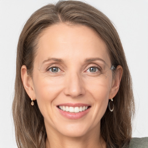 Joyful white adult female with long  brown hair and grey eyes