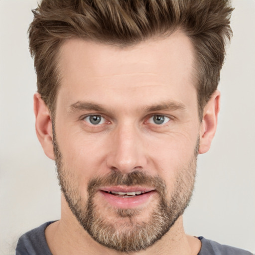 Joyful white adult male with short  brown hair and grey eyes