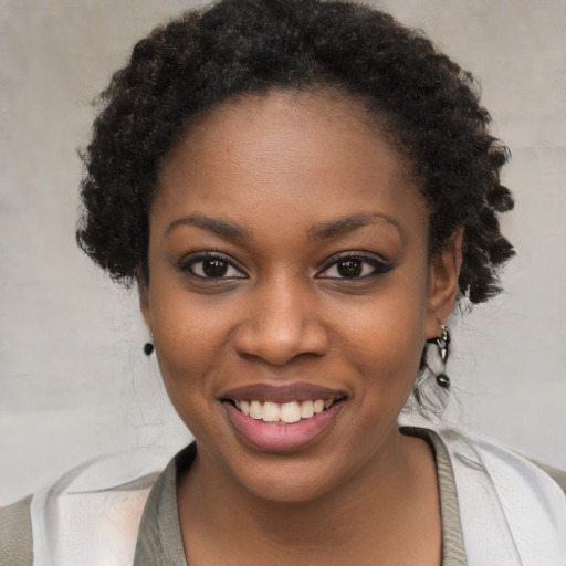 Joyful black young-adult female with short  black hair and brown eyes