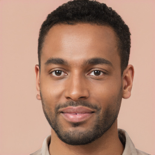 Joyful black young-adult male with short  brown hair and brown eyes