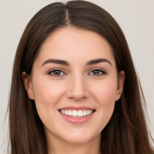 Joyful white young-adult female with long  brown hair and brown eyes