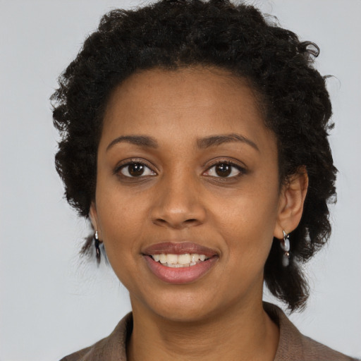 Joyful black young-adult female with short  brown hair and brown eyes