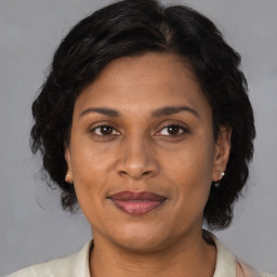 Joyful latino adult female with medium  brown hair and brown eyes