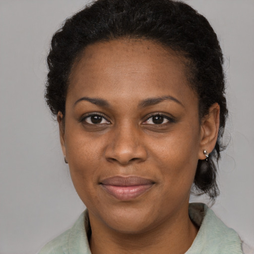 Joyful black young-adult female with medium  black hair and brown eyes