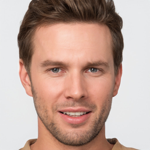 Joyful white young-adult male with short  brown hair and grey eyes