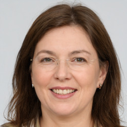 Joyful white adult female with long  brown hair and grey eyes