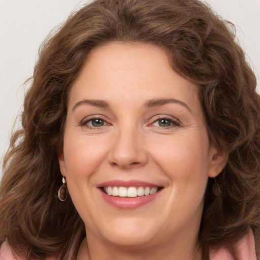 Joyful white young-adult female with long  brown hair and green eyes