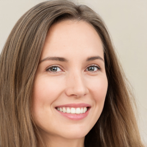 Joyful white young-adult female with long  brown hair and brown eyes