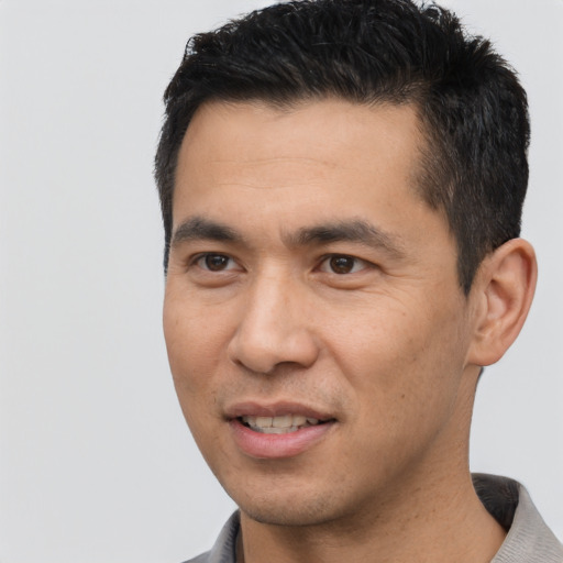 Joyful asian young-adult male with short  black hair and brown eyes