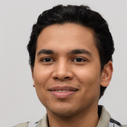 Joyful latino young-adult male with short  brown hair and brown eyes