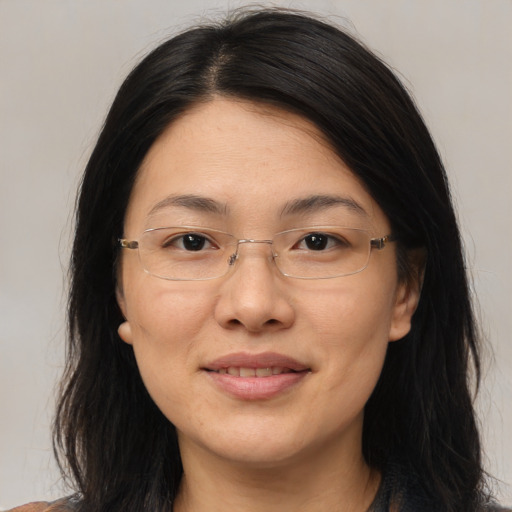 Joyful asian adult female with medium  brown hair and brown eyes