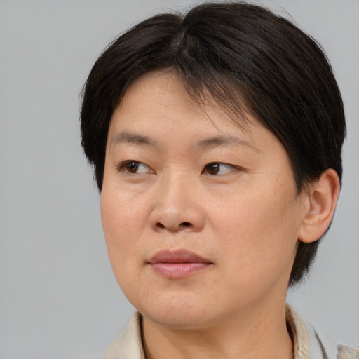 Joyful asian adult female with medium  brown hair and brown eyes