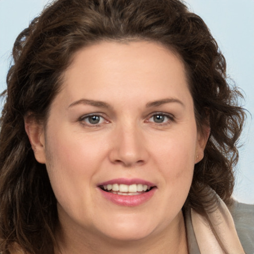 Joyful white adult female with long  brown hair and brown eyes