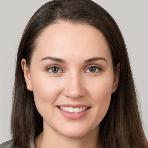 Joyful white young-adult female with long  brown hair and brown eyes