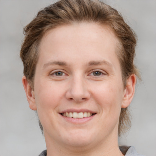 Joyful white young-adult female with medium  brown hair and grey eyes