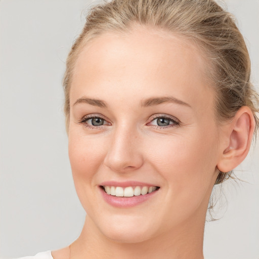 Joyful white young-adult female with medium  brown hair and blue eyes