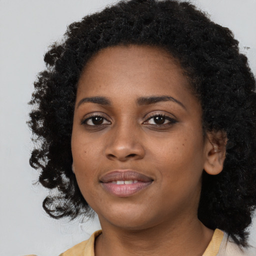 Joyful black young-adult female with long  black hair and brown eyes