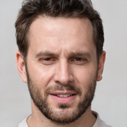 Joyful white adult male with short  brown hair and brown eyes