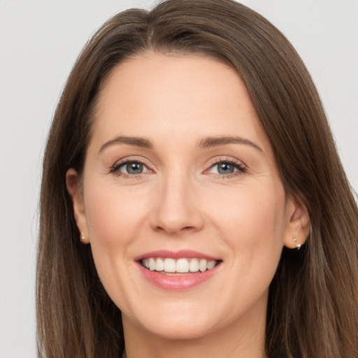 Joyful white young-adult female with long  brown hair and grey eyes