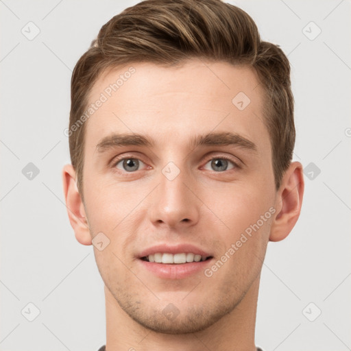 Joyful white young-adult male with short  brown hair and grey eyes