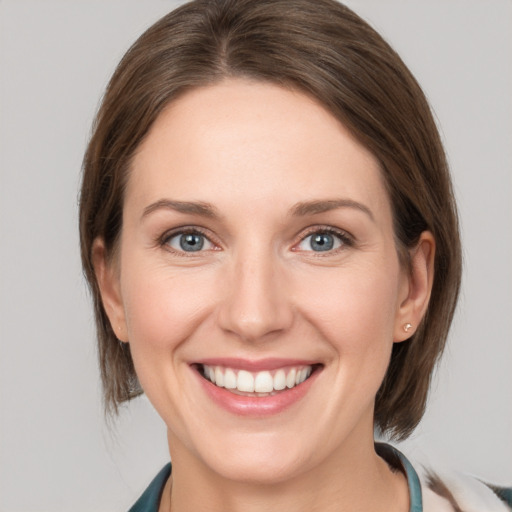 Joyful white young-adult female with medium  brown hair and grey eyes