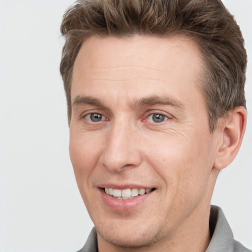 Joyful white adult male with short  brown hair and grey eyes