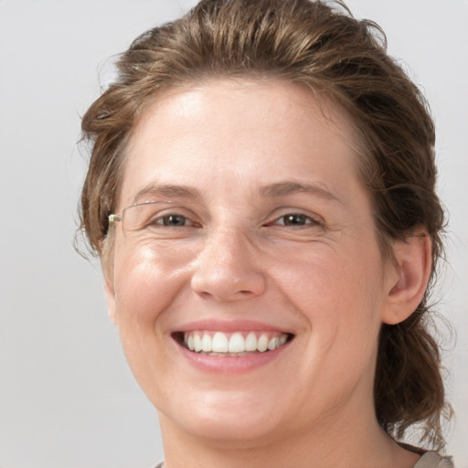 Joyful white adult female with medium  brown hair and grey eyes