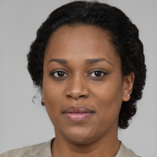 Joyful black young-adult female with short  black hair and brown eyes