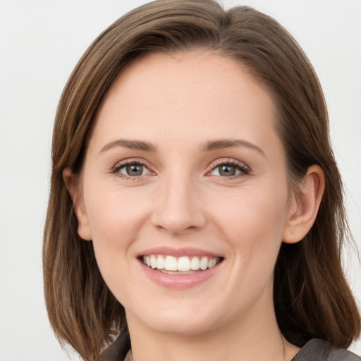 Joyful white young-adult female with long  brown hair and blue eyes