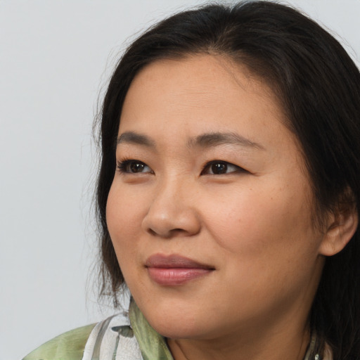 Joyful asian young-adult female with long  brown hair and brown eyes