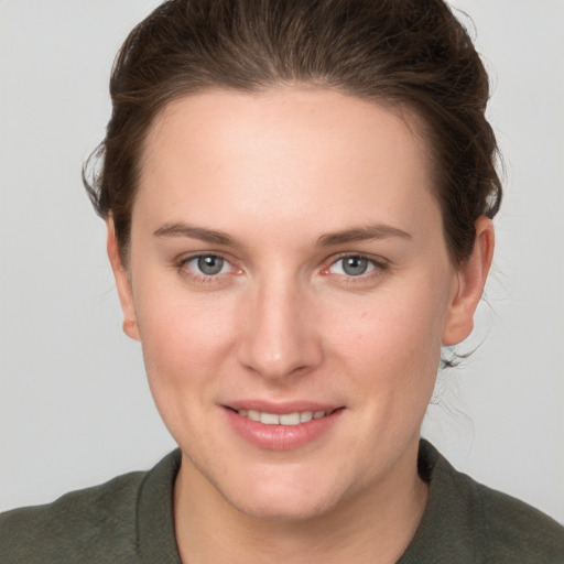 Joyful white young-adult female with short  brown hair and grey eyes