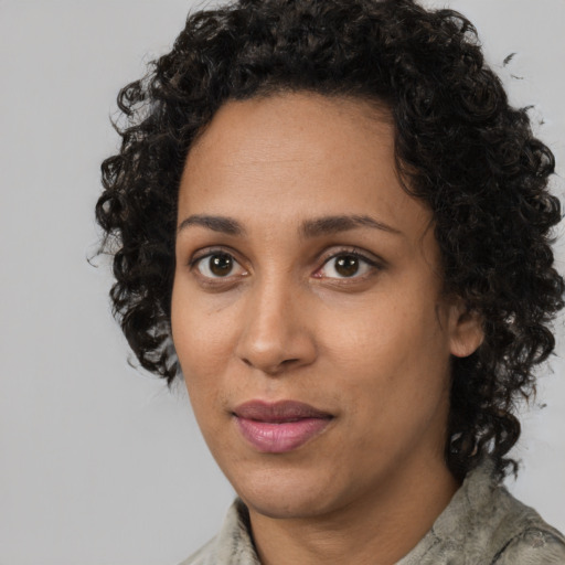 Joyful black adult female with short  brown hair and brown eyes