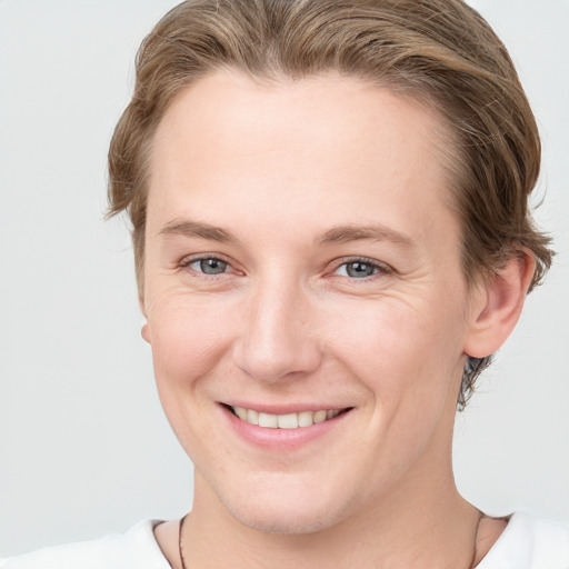 Joyful white young-adult female with short  brown hair and grey eyes